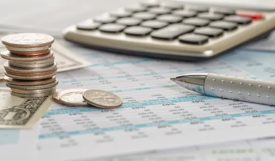 money, pen, and calculator laying on tax documents